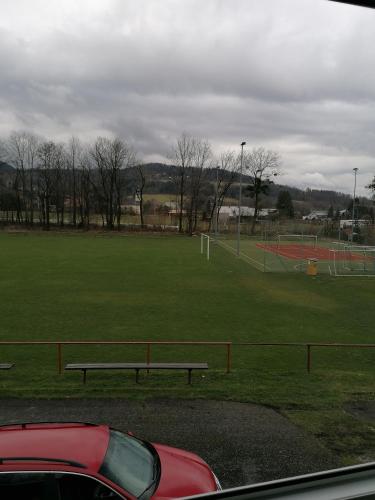 a park with a bench and a soccer field at Chatka na hřišti TJ Sokol in Ostravice