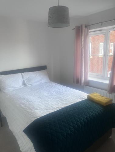 a bedroom with a large bed with a window at Market Harborough Guest House in Lubenham