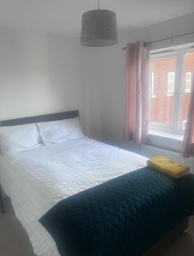 a bedroom with a large bed with a window at Market Harbour Guest House in Lubenham