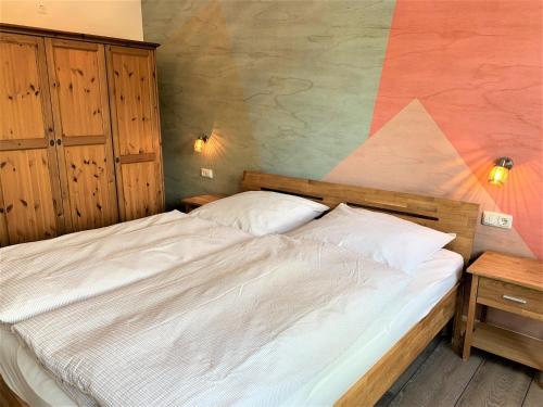 una camera con un letto bianco e una parete in legno di Die"53er" - Fit und Vital - a90094 a Grömitz