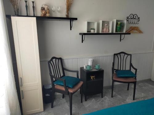 a room with two chairs and a table with a side table at Gîte Se Sentir Libre in Crozant