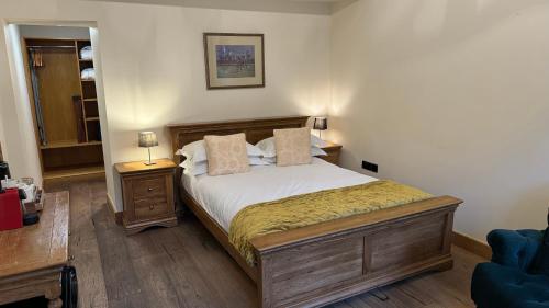 um quarto com uma cama e uma cadeira azul em The Saddle Room em Middleham