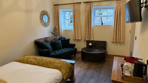 a bedroom with a bed and a couch and a chair at The Saddle Room in Middleham