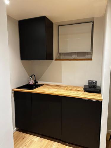 - une cuisine avec un comptoir, un évier et un miroir dans l'établissement Appartement au coeur de Strasbourg, à Strasbourg