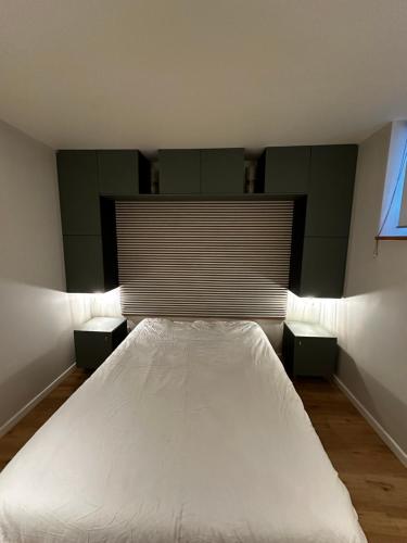 - une chambre avec un lit blanc et 2 tables de chevet dans l'établissement Appartement au coeur de Strasbourg, à Strasbourg