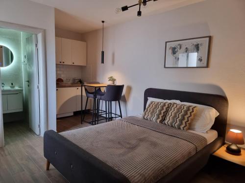 1 dormitorio pequeño con 1 cama y cocina en Apartments Vraneš Tivat, en Tivat