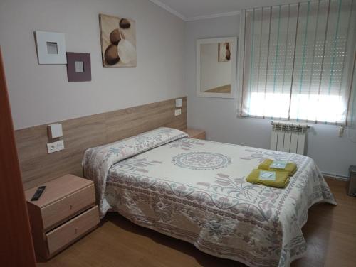 niewielka sypialnia z łóżkiem i oknem w obiekcie Apartamento SIGÜEIRO CAMINO INGLÉS (English Way) w mieście Sigüeiro