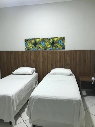 two beds in a room with a painting on the wall at OSCAR BLUE MATO VERDE in Mato Verde