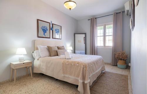 een witte slaapkamer met een bed en een raam bij La Casa Del Limonero in Peñaflor