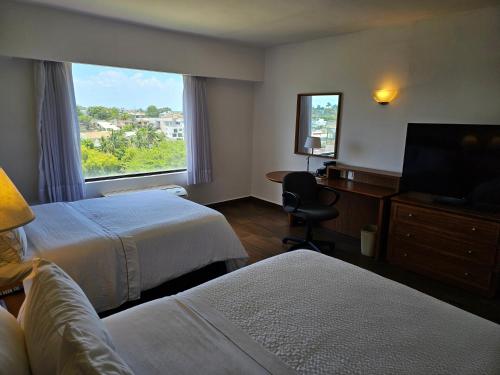 a hotel room with two beds and a window at Fiesta Inn Tampico in Tampico