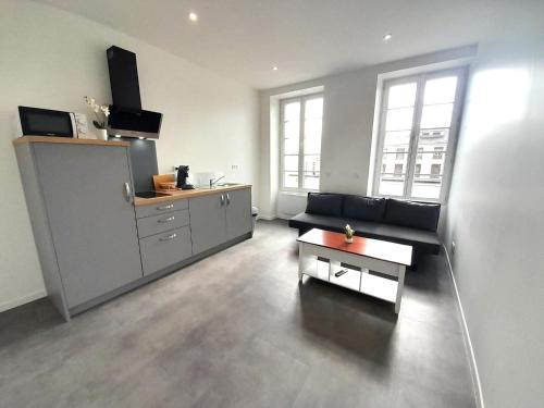 un salon avec un canapé et une table basse dans l'établissement le bugatti T2 en face de la gare, à Châteauroux