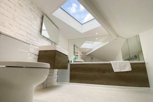 a bathroom with a toilet and a large skylight at Modern design 3BRs 2F house close to Victoria in London