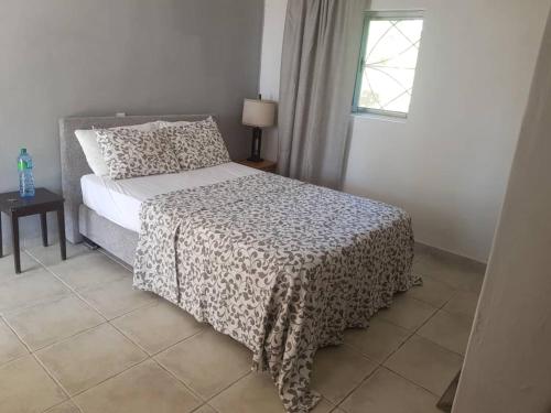 Dormitorio con cama con manta de leopardo en Poco Loco B&B, en Abémé