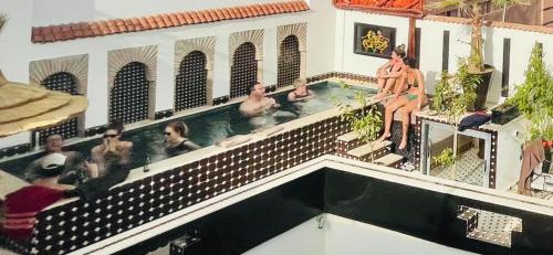 a group of people sitting in a swimming pool at Dar Najat in Marrakech