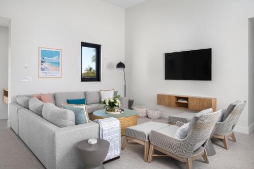 a living room with a couch and chairs and a tv at Upper East Side Enclave #14 in Long Bay Hills