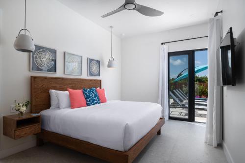 a bedroom with a bed with a ceiling fan at Upper East Side Enclave #14 in Long Bay Hills