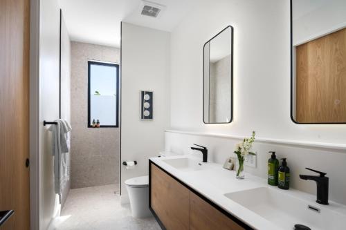 a bathroom with a sink and a toilet and a mirror at Upper East Side Enclave #14 in Long Bay Hills