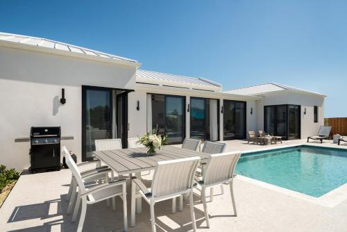 a patio with a table and chairs next to a pool at Upper East Side Enclave #14 in Long Bay Hills