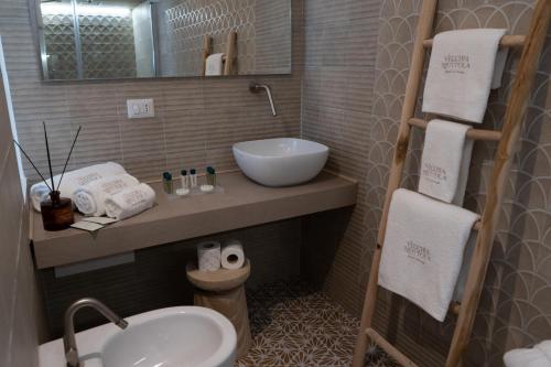 a small bathroom with a sink and a mirror at Vecchia Mottola Private Suite & Spa in Mottola