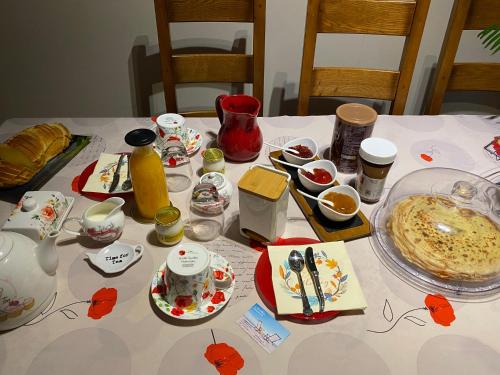 a table topped with plates and bowls of food at LE CLOS D'HERBLAY Chambres d'Hôtes in Herblay