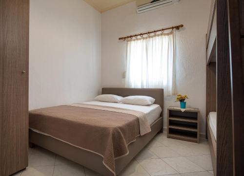 a bedroom with a bed and a window at Lofos Kalamitsi in Kalamitsi