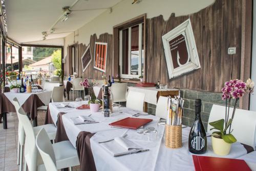 restauracja ze stołami, białymi krzesłami i stolikiem w obiekcie Crotto dei Pescatori w mieście Lezzeno