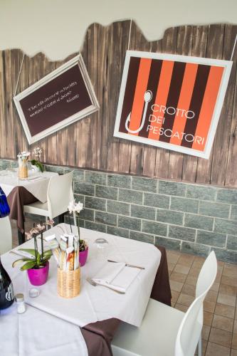 a dining room with tables and chairs and a brick wall at Crotto dei Pescatori in Lezzeno