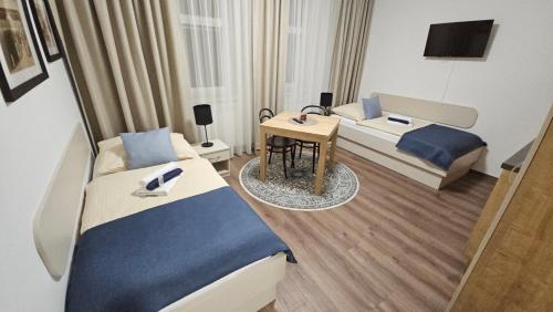 KoryčanyにあるPenzion Vila Winterのベッド2台とデスクが備わるホテルルームです。