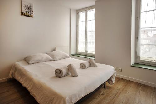 uma cama num quarto branco com duas almofadas em Centre-ville - calme -proche gare em Angoulême