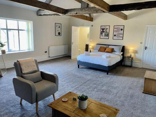 1 dormitorio con 1 cama, 1 silla y 1 mesa en Rear of Northway Court Farm en Tewkesbury