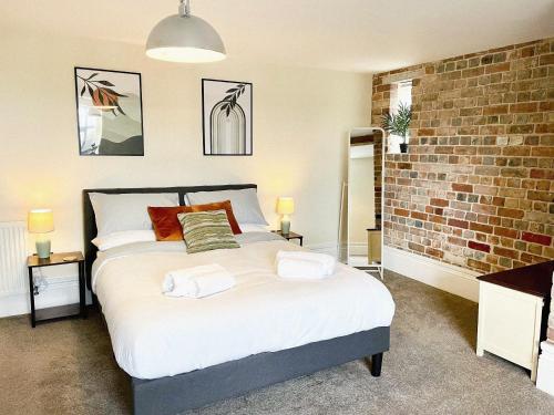 a bedroom with a bed and a brick wall at Rear of Northway Court Farm in Tewkesbury