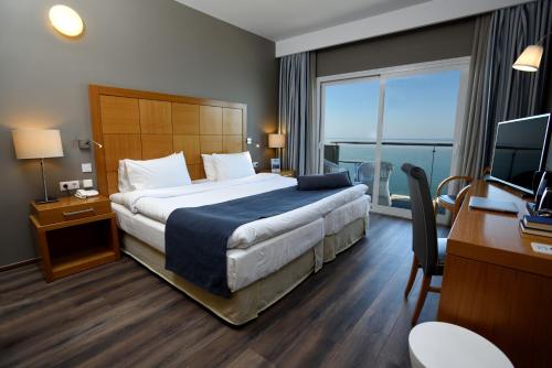 a hotel room with a bed and a desk and a television at Golden Star City Resort in Perea