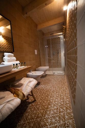 a bathroom with two sinks and a toilet and a shower at Vecchia Mottola Private Suite & Spa in Mottola