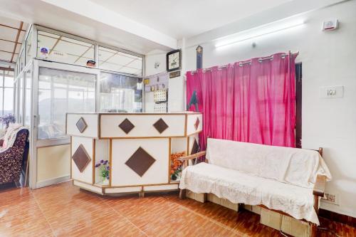 a living room with a bench and pink curtains at Hotel Shimla View in Jutogh