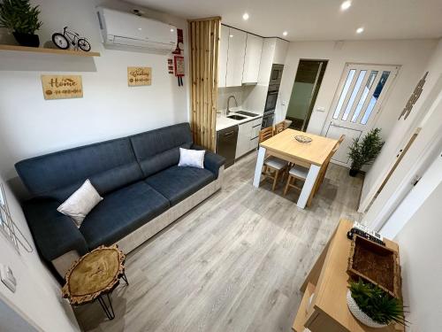 a living room with a blue couch and a kitchen at Cantinho do Vale - Oleiros in Oleiros