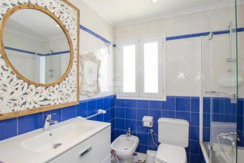a bathroom with a toilet and a sink and a mirror at Apartamento en Cala en Porter, Menorca. in Cala'n Porter