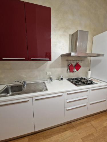 a kitchen with white cabinets and a sink at Casa Francesca in Livorno
