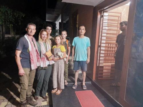 a group of people standing outside of a house at The PALM SUITES , Incredible India Tourism in Guwahati