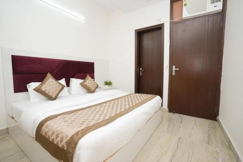 sypialnia z dużym łóżkiem z drewnianymi drzwiami w obiekcie Hotel Diamond Stay, Nizamuddin Railway Station w Nowym Delhi