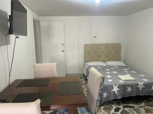 1 dormitorio con cama, mesa y TV en Apartamento cómodo , céntrico y bien ubicado Apto 301, en Medellín