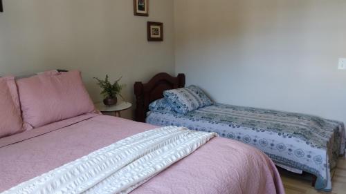 1 Schlafzimmer mit 2 Betten und einem Stuhl in der Unterkunft Casa flores do campo in Campos do Jordão