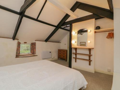 sypialnia z białym łóżkiem i oknem w obiekcie Dunridge Cottage w mieście Yelverton