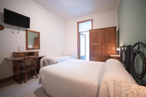 a bedroom with two beds and a desk and a mirror at Hotel Leon D'Oro in Alfedena