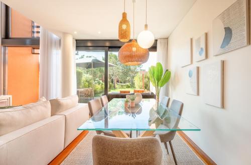 a dining room with a glass table and chairs at Tróia Villa Serenity in Troia