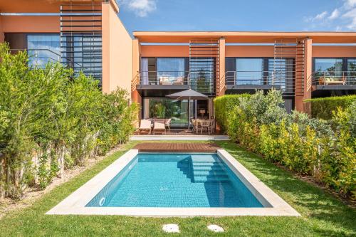 a house with a swimming pool in front of it at Tróia Villa Serenity in Troia