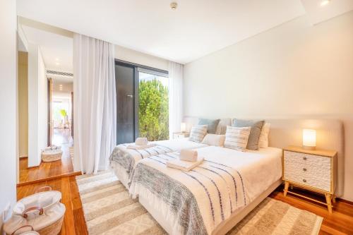a bedroom with a large bed and a large window at Tróia Villa Serenity in Troia