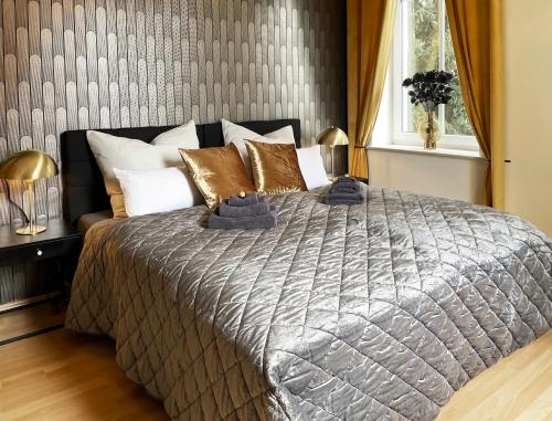 um quarto com uma cama grande e almofadas douradas em NEU! Art Deco Design-Luxus-Apartment, am Markt, Garten em Gera
