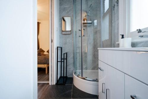 a bathroom with a glass shower and a sink at Charming & Relaxing ~ Walk to Tube ~ 2BRs&2Bths in London
