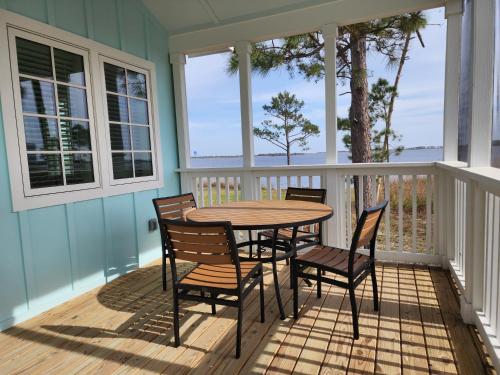 a porch with a table and chairs on it at Eagle Cottages & The Cabins at Gulf State Park in Gulf Shores