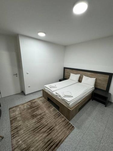 a bedroom with a bed with white sheets and pillows at Lux apartment Bijeljina in Bijeljina